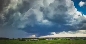 Storm clouds moving across an Ohio landscape, illustrating how weather influences forest growth and timber management
